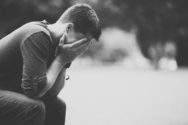 student with head in hands grieving
